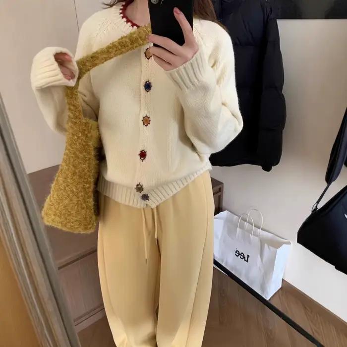 La collection automne/hiver 2025 comprend un pull de Style ralenti à col rond et boutons de couleur présentant un Cardigan tricoté haut de gamme